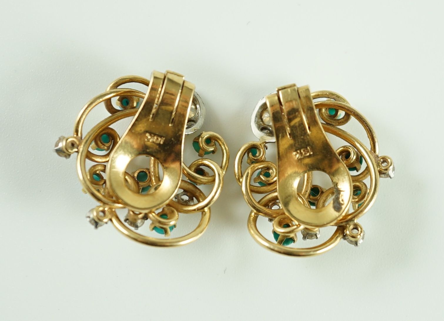 A pair of modern 18k gold diamond and turquoise cluster set scrolling ear clips